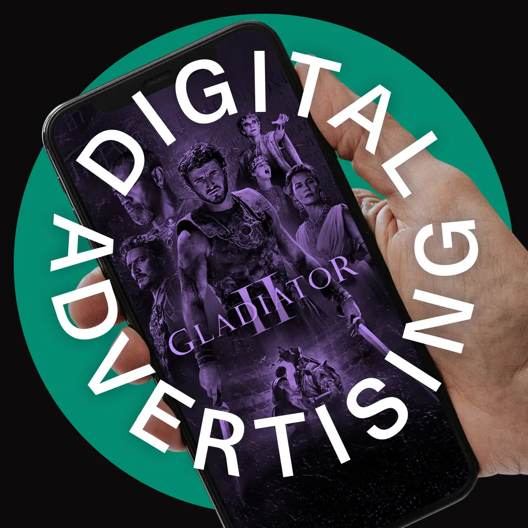 Digitale Werbung für den Film "Gladiator 2" auf einem Smartphone-Bildschirm, gehalten von einer Hand. Der Text "DIGITAL ADVERTISING" umrahmt das Telefon.